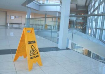 Caution wet floor on a commercial tile floor Janitorial Services: How to Choose the Best Provider for Your Work Place