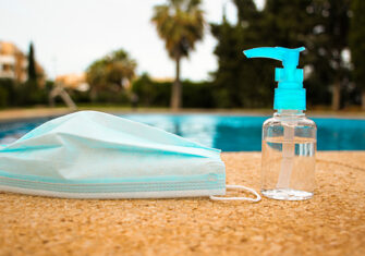 COVID-19 hand sanitizer and mask by a pool Coronavirus Disinfection - Pool Area Cleaning and Disinfection for HOAs and Multi-Family Locations