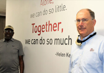 Jerry Anderson and Joe Budd in front of The Budd Group sign Together We Accomplish More