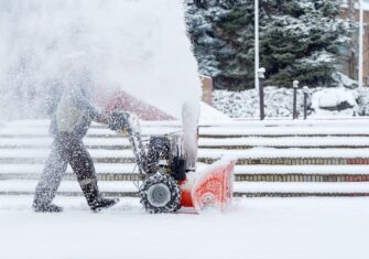 Snow removal on a sidewalk Snow and Ice Removal: When to Call in a Professional