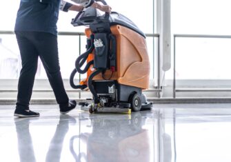 Person cleaning a commercial floor Best Types of Floor Care Maintenance for Your Facility