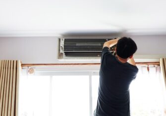 Person working on the AC in their condo How to Tackle Condo Maintenance This Summer