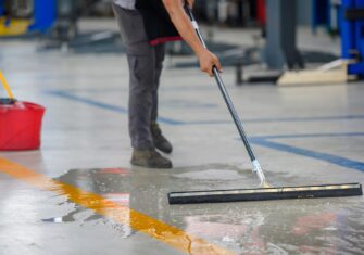 Man cleaning a warehouse floor Top 5 Floor Care Tips for Your Warehouse in the Spring