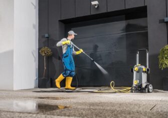 Power washing a black garage door. Top 5 Reasons to Powerwash Your Commercial Facility at the End of Summer